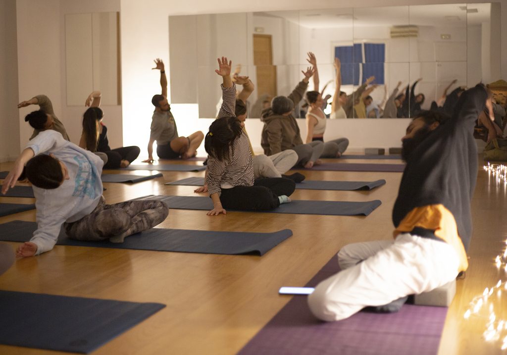Vinyasa-Yoga-clase-estudiantes-extensión-lateral-sentada